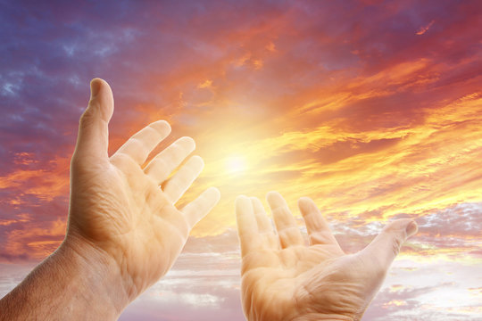 Hands reaching out in sunny sky