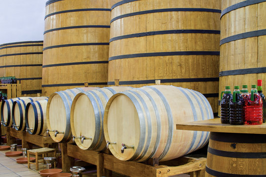 Big and small yellow barrels with iron rims and plastakovy bottles with drinks.