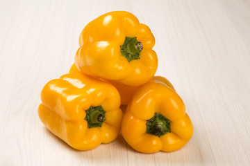 Some red, green and yellow peppers over a wooden surface
