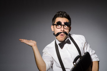 Young man with false moustache isolated on gray