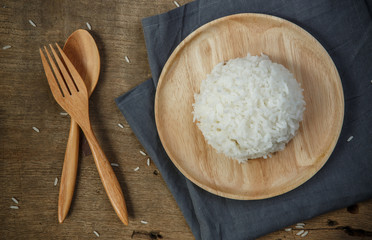 Thai jasmine rice in wooden dish with napery and wooden spoon -
