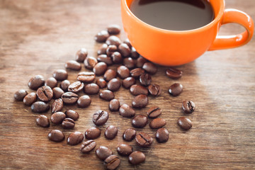 Coffee beans with coffee cup on wooden table