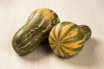 Some Paulistan pumpkins in a basket over a wooden surface on a p