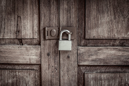 locked wooden door with silver padlock