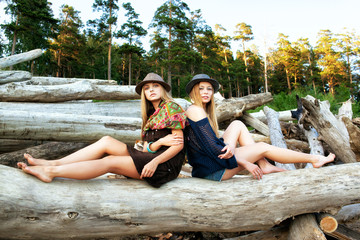 Young women on logs in the forest