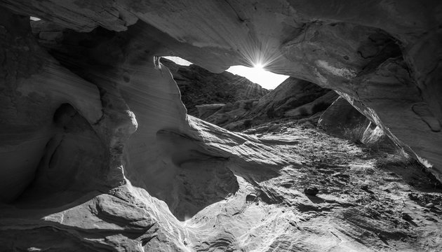 Sun peeking from behind the arch Black and White Abstract Rock F