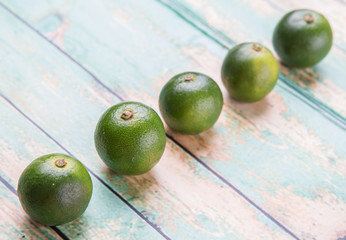 Calamansi citrus over weathered wooden background