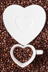 cup and saucer on coffee beans background