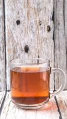 A mug of tea over weathered wooden background