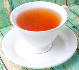 A cup of tea over weathered wooden background