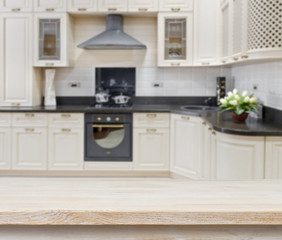 Wooden textured table over blurred kitchen interior background