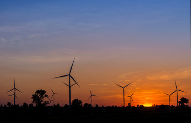 Fototapeta na wymiar Eco power in wind turbine farm with sunset