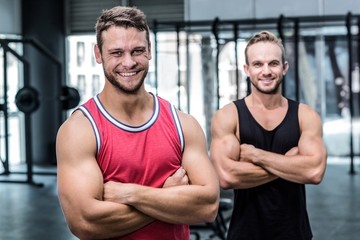 Fototapeta na wymiar Two smiling muscular men with arms crossed