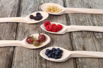Different ripe berries in a spoons