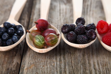 Different ripe berries in a spoons