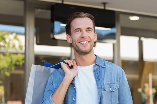 A smiling man with shopping bags