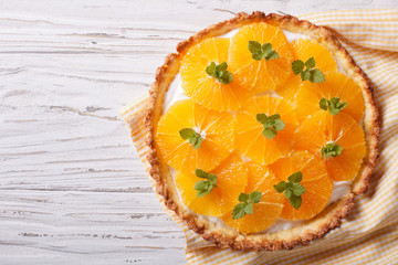 Tasty orange citrus tart with white cream. Horizontal top view
