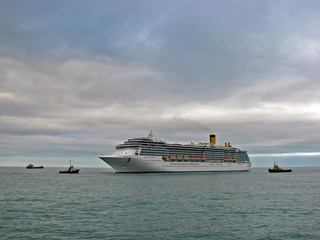 Cruise ship and tugboats at anchorage