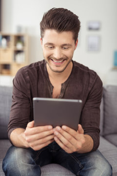 mann liest zuhause am tablet-pc