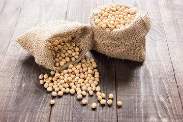 Soybean in a bag on wooden background.