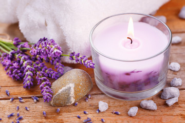 Spa stil life with perfumed candle, white towel, stones and lavender flowers 