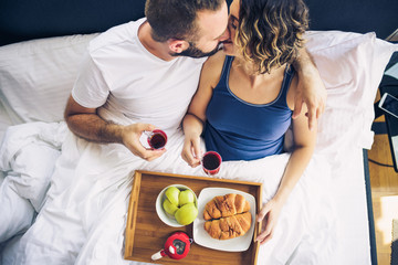 Couple having breakfast in bed, aerial view