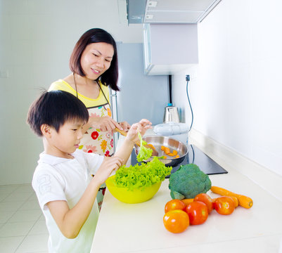 Asian mother and son cooking in the kitchen