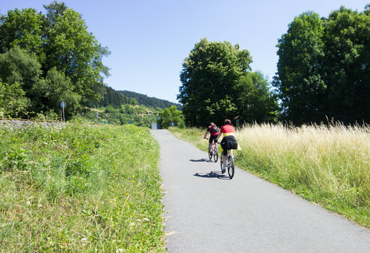couple travelling on bicycles on country track 