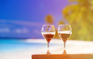 two wine glasses on sand beach