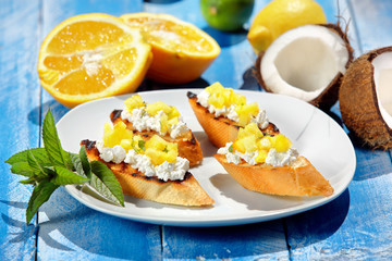 Crostini with pineapple on a blue wooden background