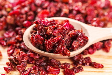 Dry red barberry spices in the wooden spoons