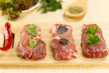 fresh raw pork on cutting Board with spices and herbs