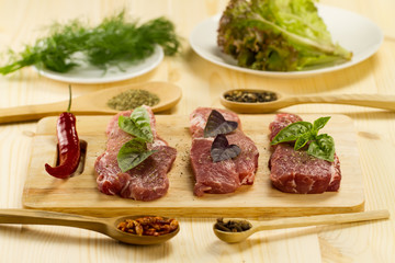 fresh raw pork on cutting Board with spices and herbs