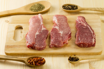 fresh raw pork on cutting Board with spices and herbs