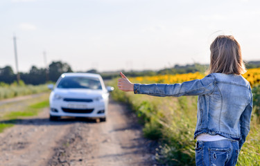 Girl Showing Thumbs Up to a Car Passing the Road