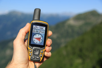 Hand held outdoor GPS being used for navigation in the mountains.
