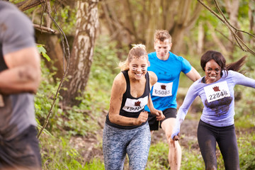 Three competitors running in a forest at an endurance event