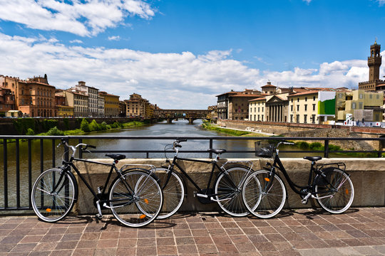 three bikes photographed on the bridge over the River Arno , Florence , Italy 