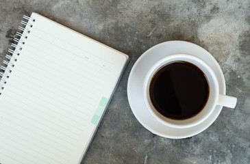 notepad and a cup of coffee on the concrete table in the office