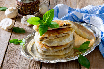 Pastry stuffed with mushrooms and onions on a wooden table