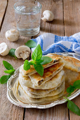 Pastry stuffed with mushrooms and onions on a wooden table