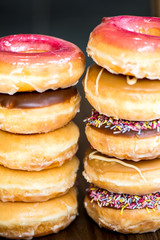 Stacks of Glazed Doughnuts with colourful sprinkles, chocolate,