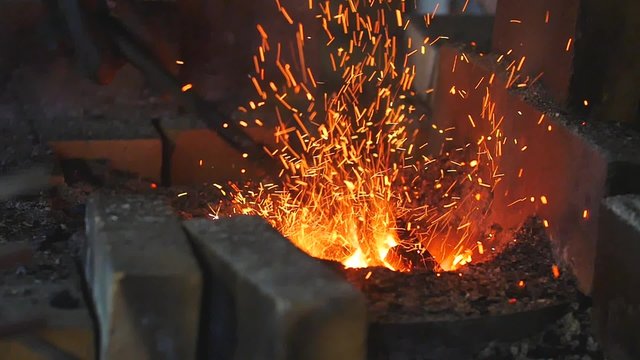 Blacksmith work with metal and fire forge, slow motion.