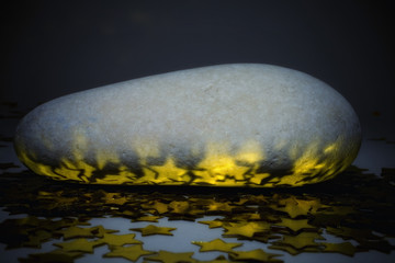 oval stone with golden stars closeup
