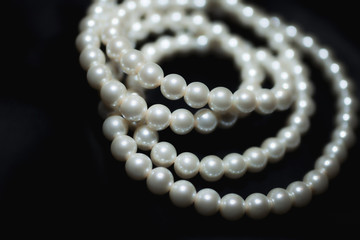 white pearl necklace on black silk