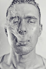 man with a silvery makeu in the smoke