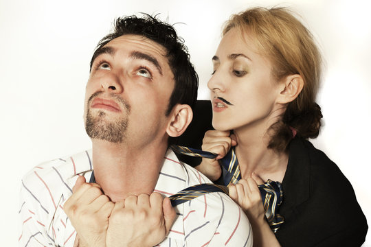 woman  strangling a young man tie