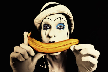 mime in white hat holding a banana in his hand