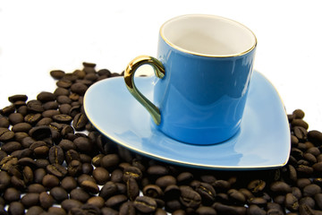 Blue cup and saucer with grains of coffee