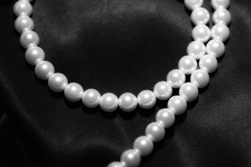 white pearl necklace on a black silk close up